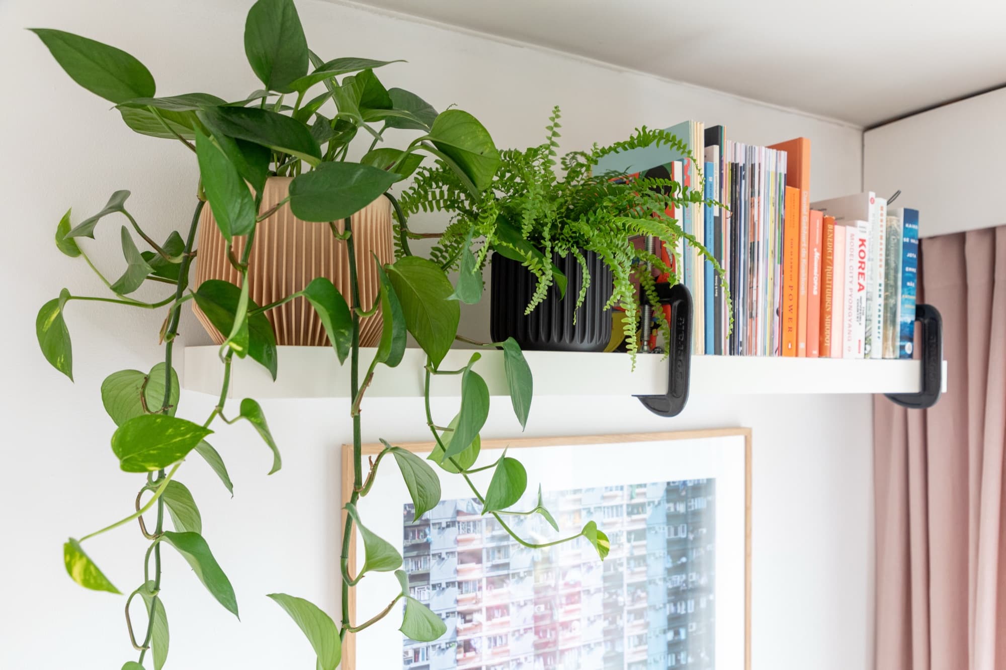 Three 3D-printed flower pots of graduated sizes arranged on a wooden shelf